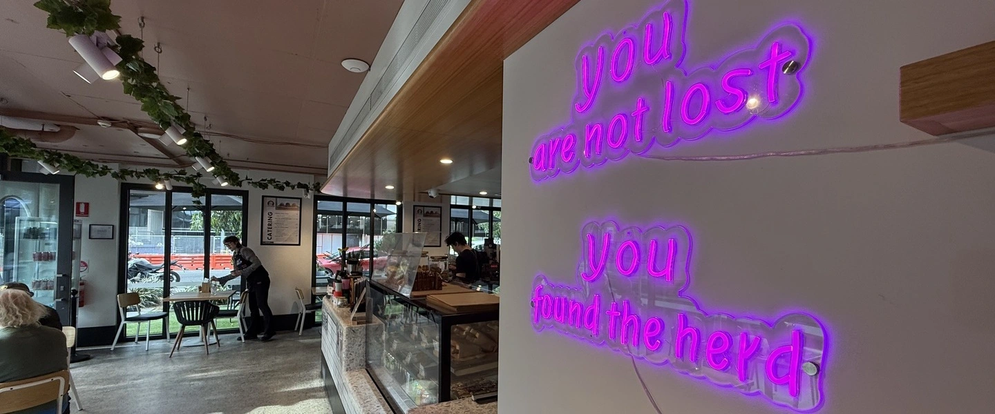 Lost Sheep Cafe interior with neon sign reading you are not lost you found the herd